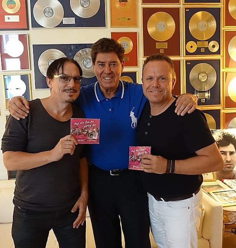 Das Musikverlag-Team vor goldenen Schallplatten